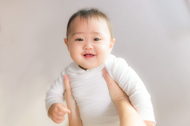 抱き上げられて笑う赤ちゃん