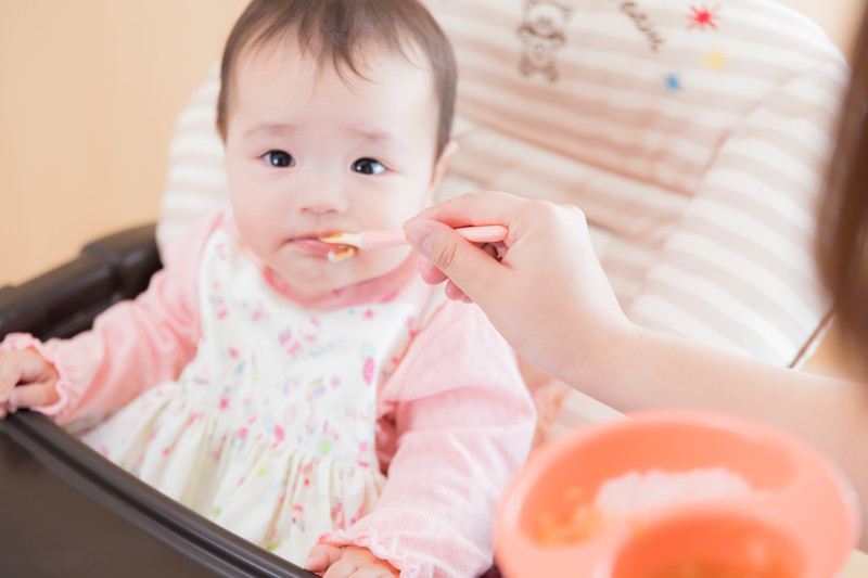 赤ちゃんに離乳食をあげる女性