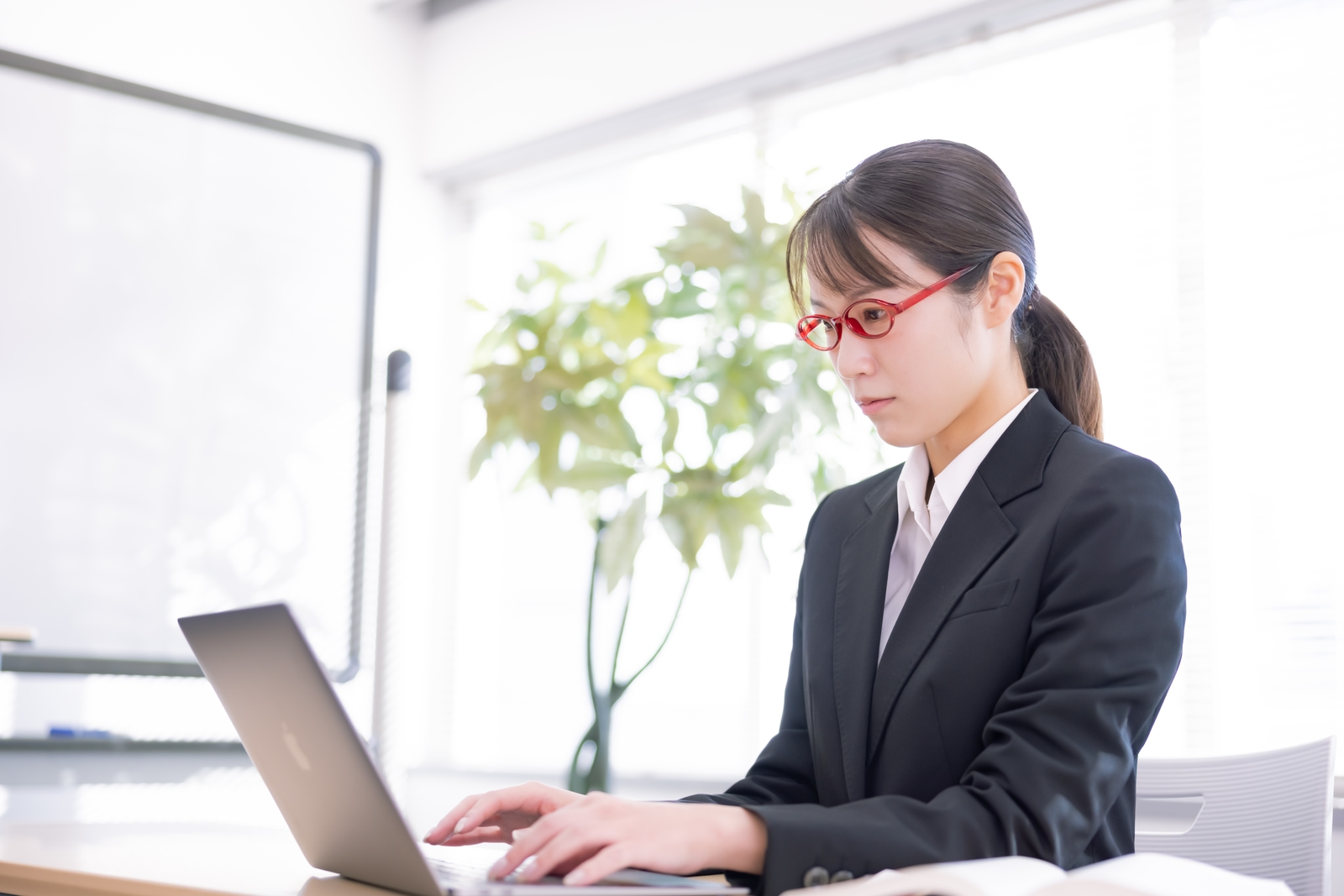 真剣な表情でパソコンに向かう女性