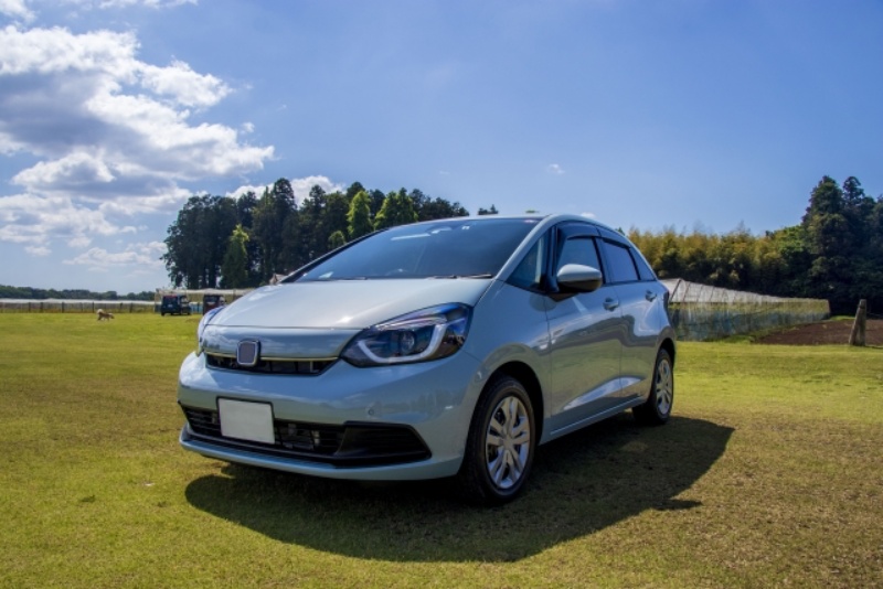 青空と緑の芝生をバックに写るホンダ車